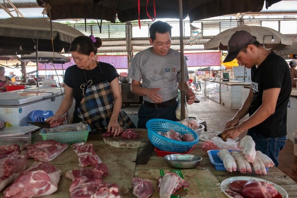 Hung Nguyen, scientist ILRI food system specialist visiting Dong Xa Market.
